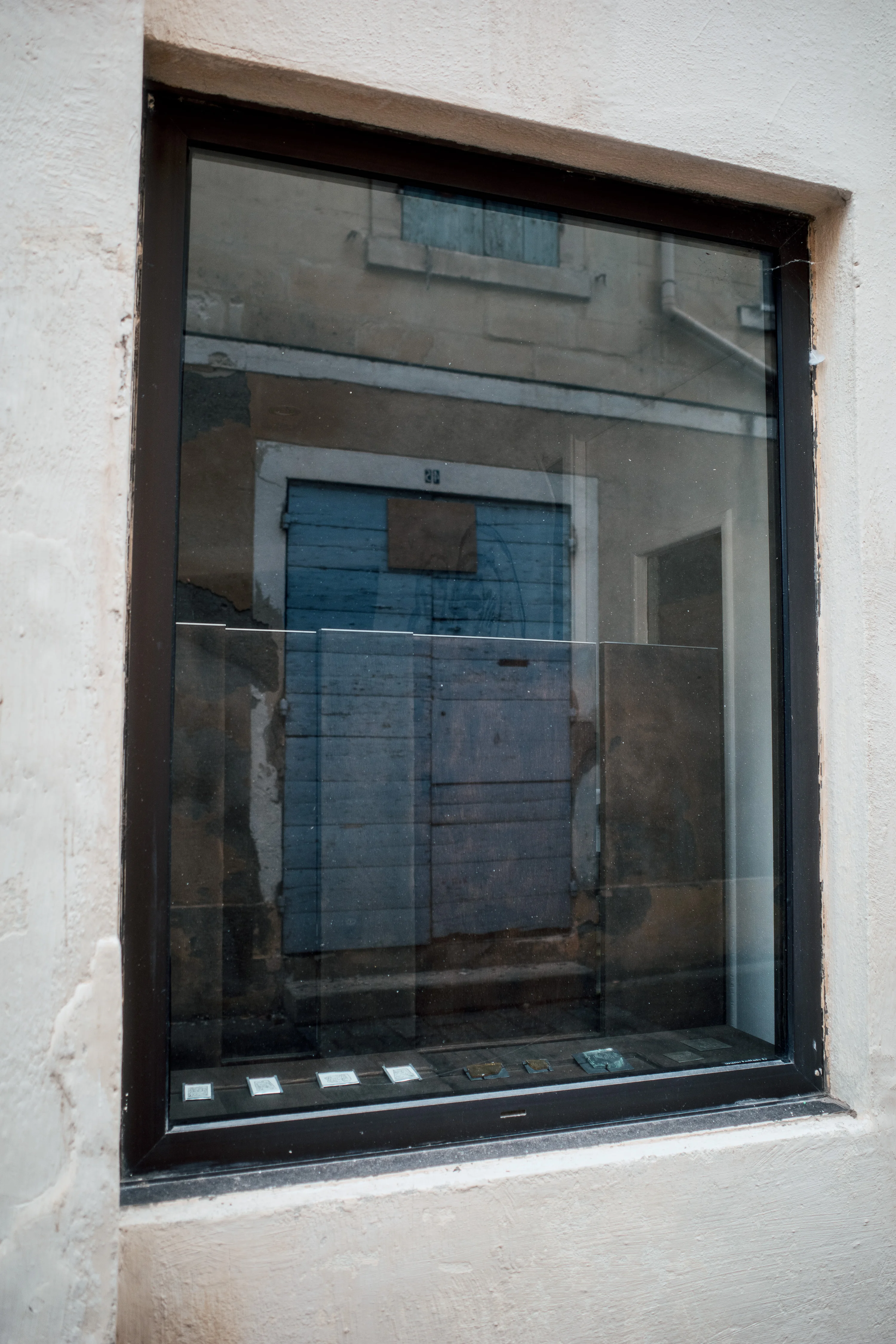 Reflection of a blue door in a building window.