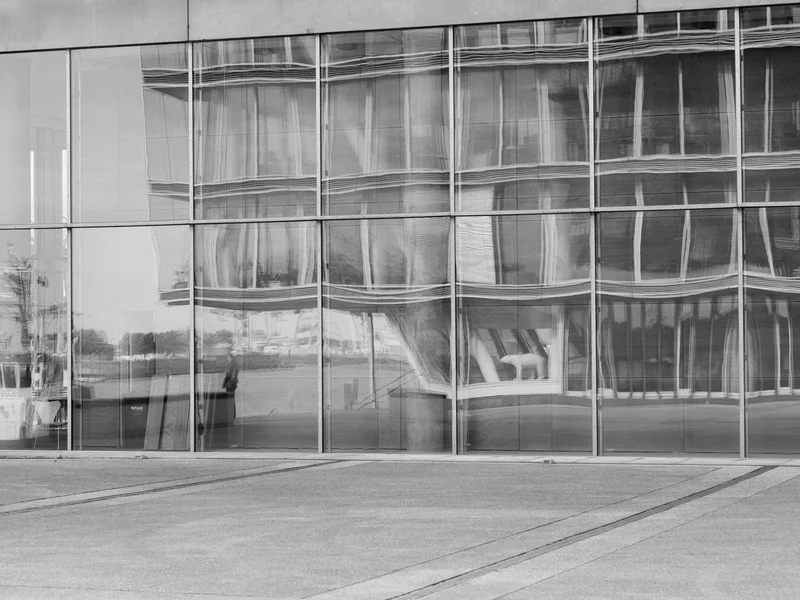 Distorted reflection of a building on glass panels.