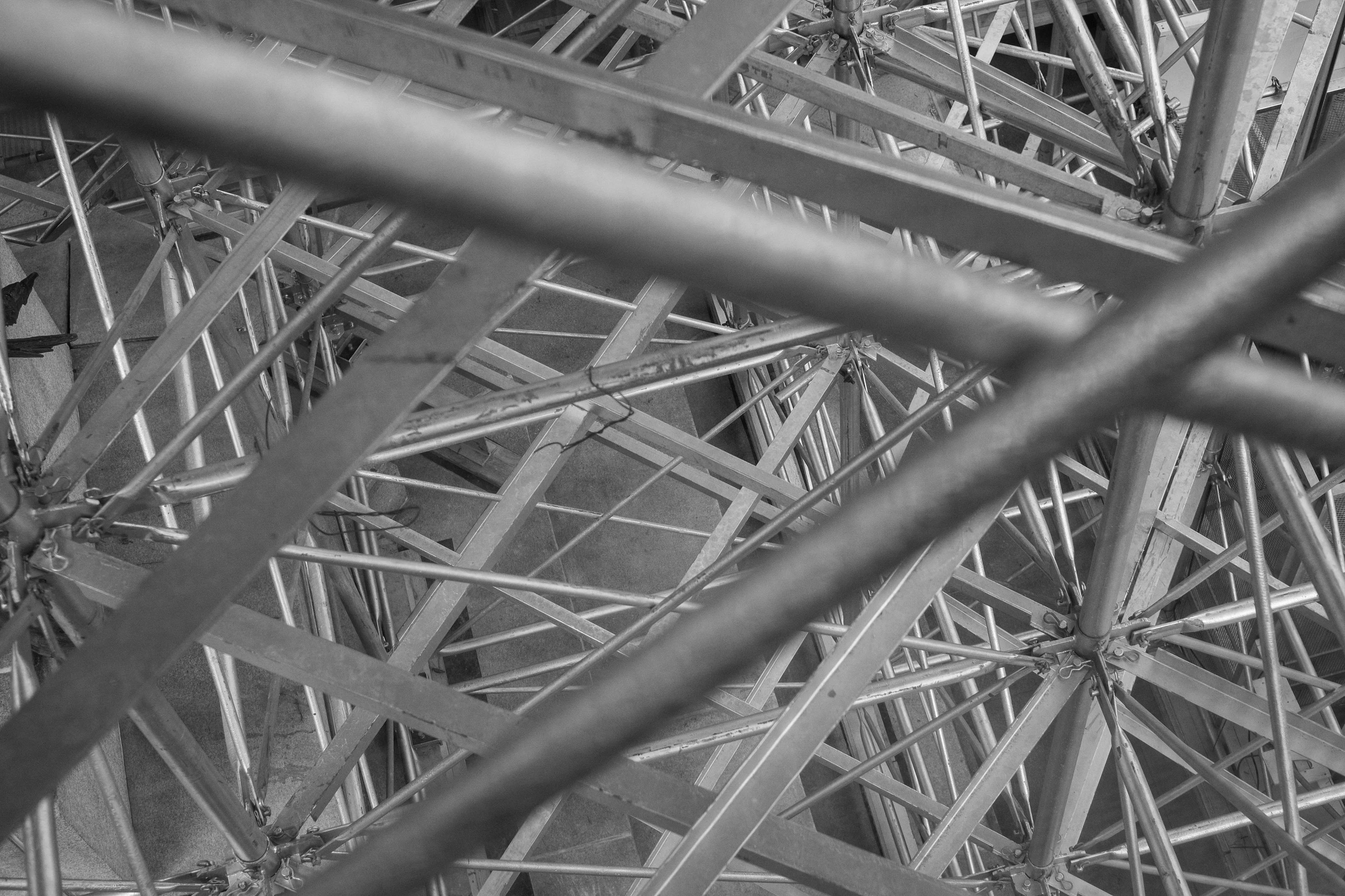 Black and white photograph of an intricate network of intersecting metal beams.